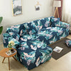 A dark blue and green floral patterned L-shaped sofa protector cover displayed on a light-colored wall.