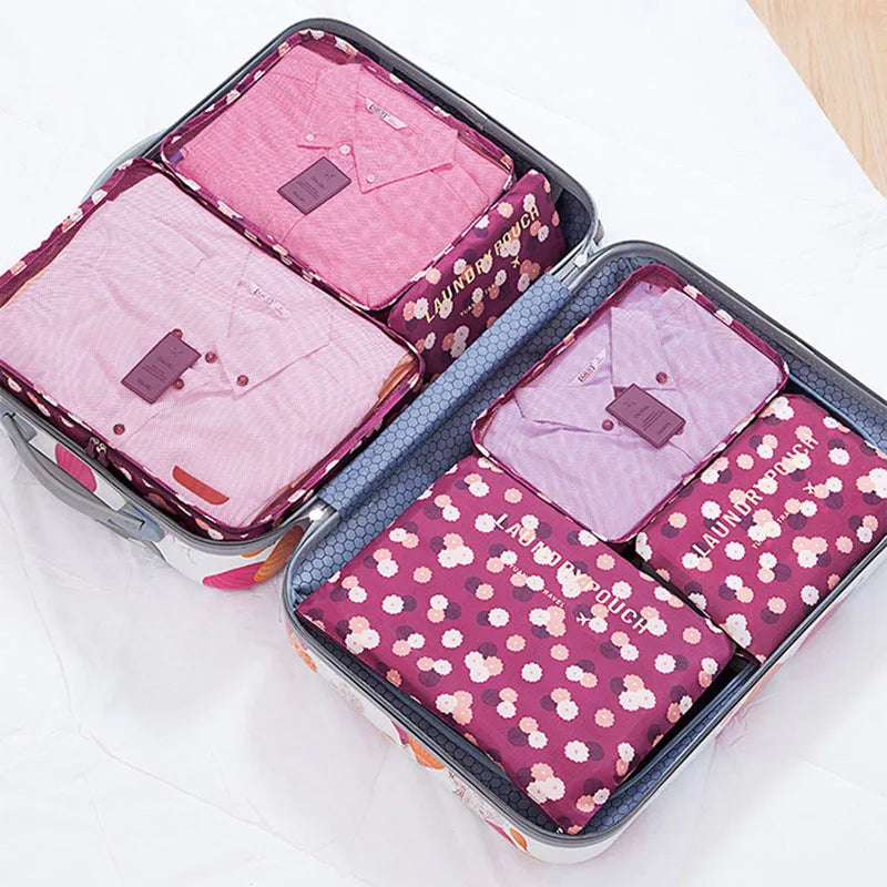 A storage organizer set containing six pink and purple fabric pouches for clothes.