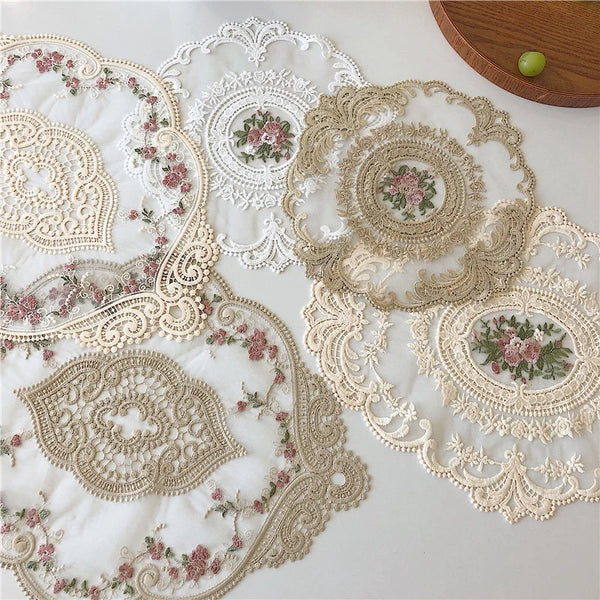 Elegant oval lace embroidered coaster set featuring delicate floral patterns in beige and pink on white fabric
