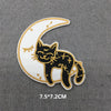 A black cat embroidered on a white crescent moon patch with gold accents.