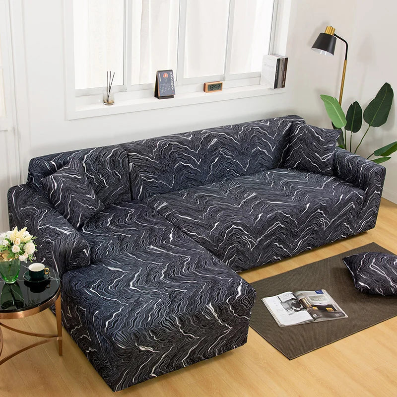 A dark gray and white patterned L-shaped sofa protector cover placed on a wooden floor.