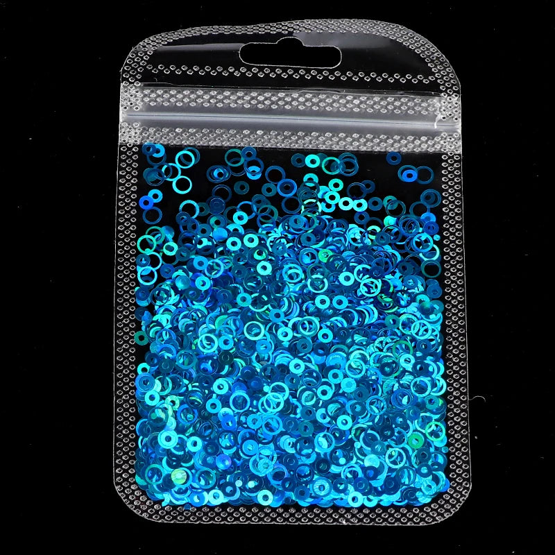 A clear plastic bag filled with bright blue and teal sparkly resin glitter filler for epoxy art