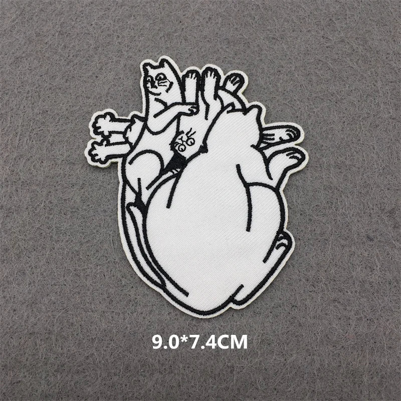 A white embroidered patch featuring a cat with a striped tail and a small butterfly on its body.