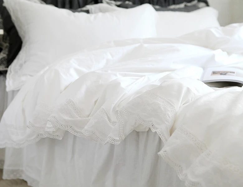 White luxury ruffle duvet cover displayed on a bed, showing delicate lace trim.