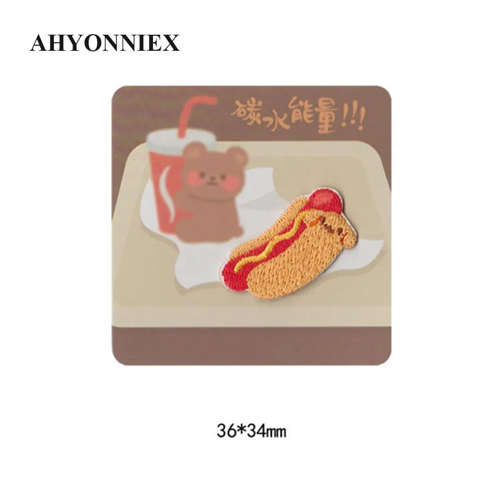 A square patch featuring an embroidered illustration of a sandwich and a cup, with Chinese text above it.