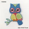 A blue and pink embroidered owl patch with yellow accents.