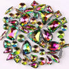 A collection of 50 silver claw rhinestones and decorative gems in various shades of iridescent pink, green, and purple.