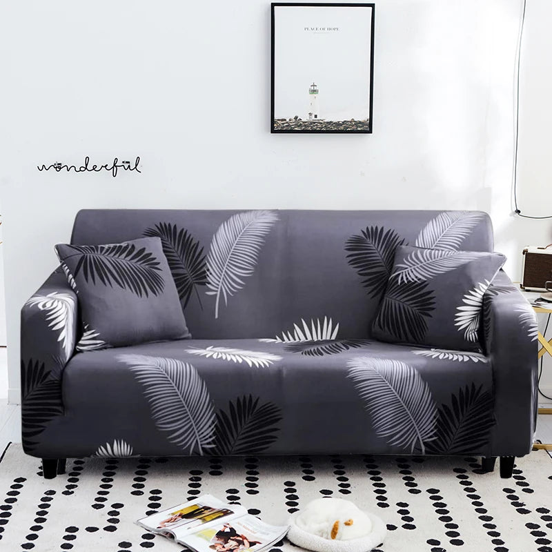 A dark gray stretch floral elastic sofa cover featuring a black and white palm leaf pattern.