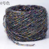A ball of metallic gray merino wool yarn with iridescent fibers for hand knitting