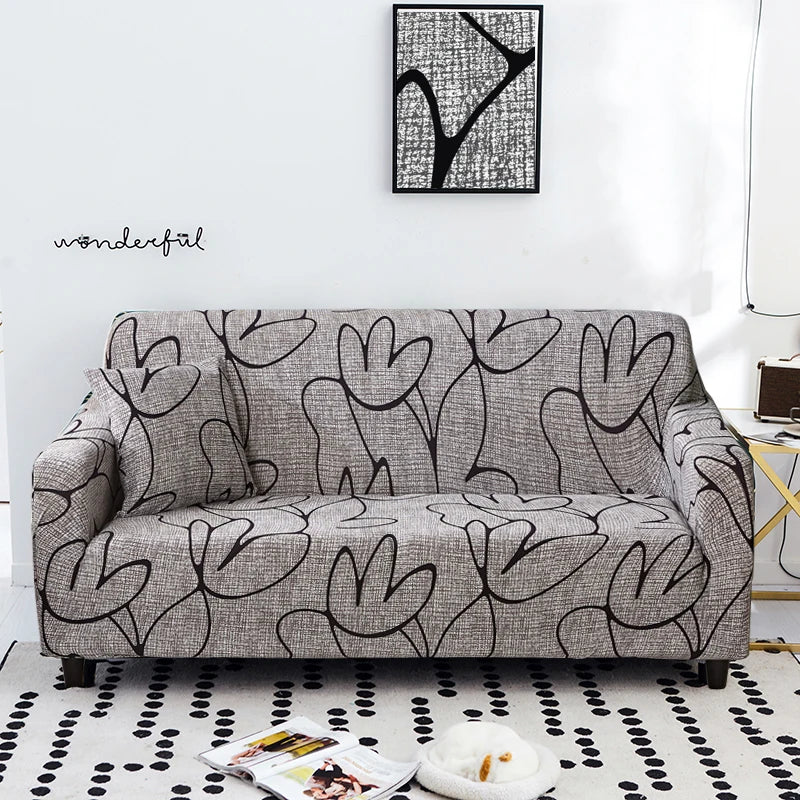 A gray stretch floral elastic sofa cover featuring a black and white abstract tree pattern on a living room sofa.