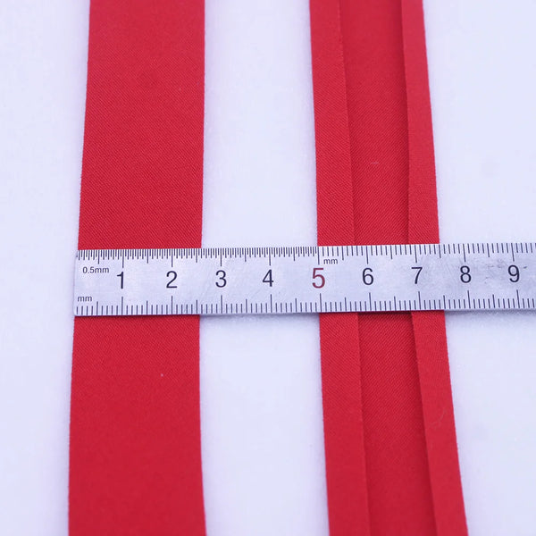 Two parallel red bias tape binding ribbons measured against a ruler.
