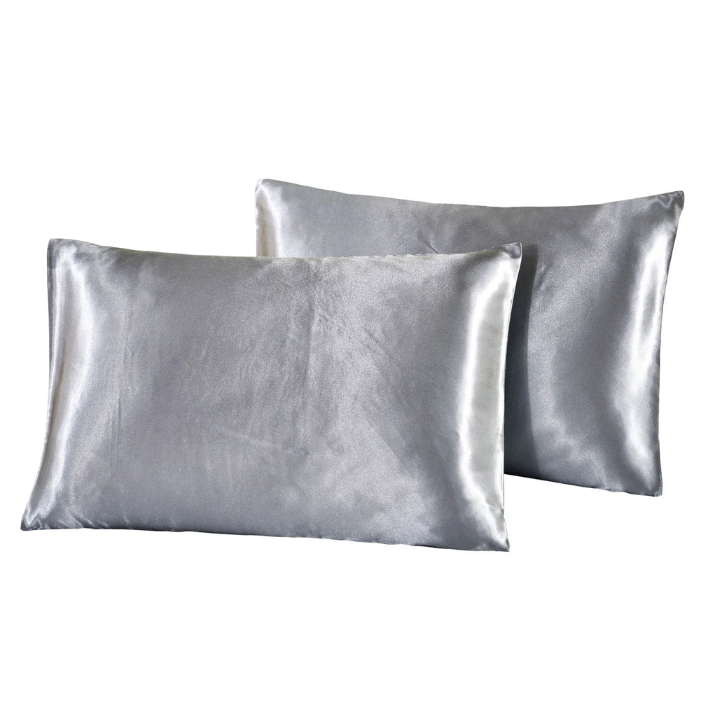 A stack of smooth, silver-gray silky satin pillowcases.