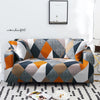 A modern sofa covered in a geometric pattern of gray, black, white, and orange fabric.