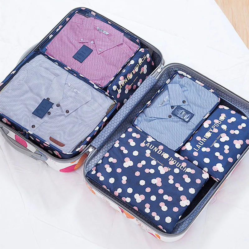 A storage organizer set containing six folded shirts and other clothing items in various shades of pink and blue.