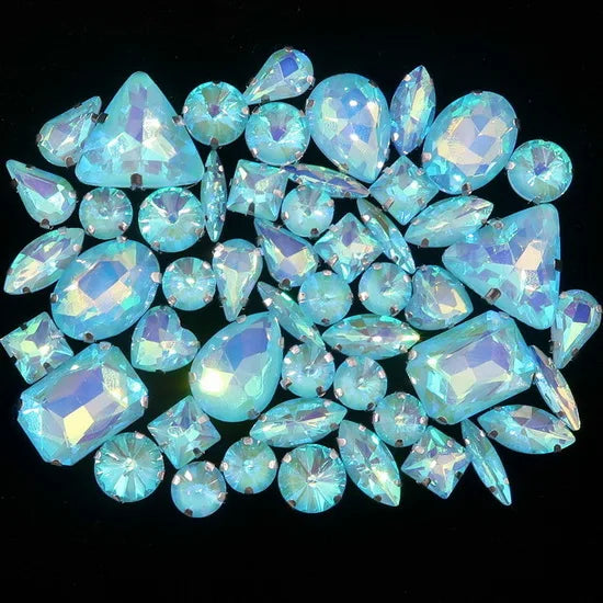 A close-up view of a set of light blue silver claw rhinestones arranged on a dark background.