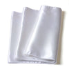 A roll of elegant white satin fabric used as a table runner or home decor