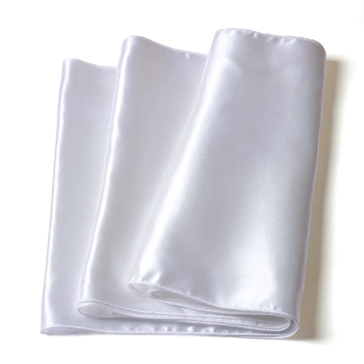 A roll of elegant white satin fabric used as a table runner or home decor