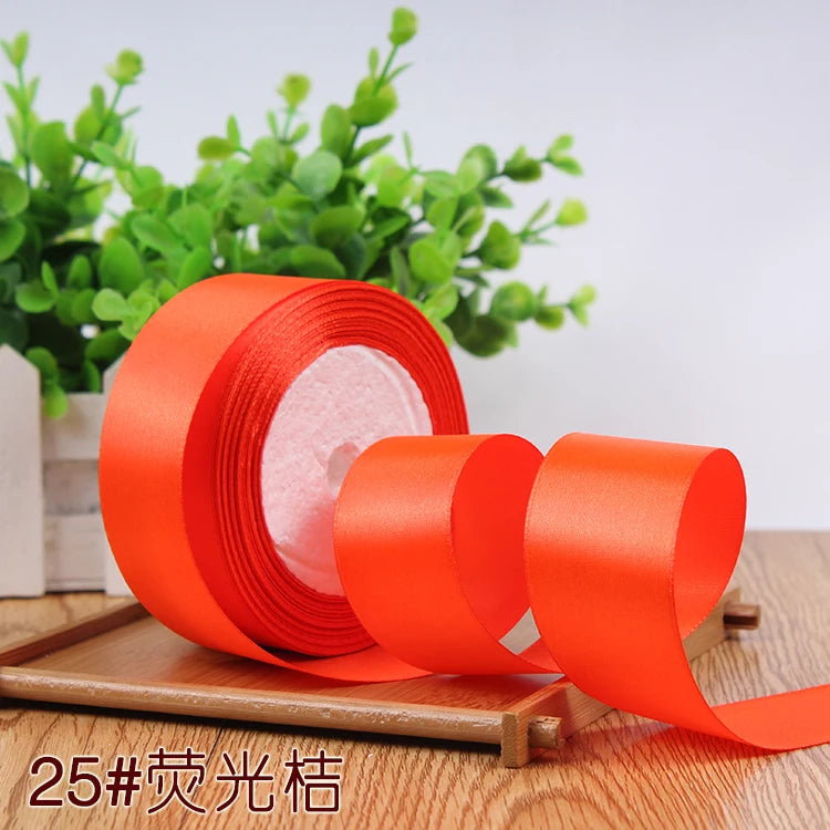 Roll of bright orange satin ribbon for gift wrapping and DIY crafts