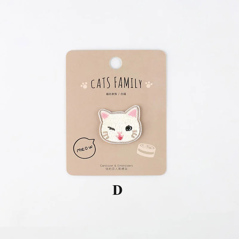 A beige iron-on patch featuring a white embroidered cat face and the text Cats Family.