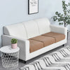 A white sofa with a tan seat cushion cover and a potted plant on a small side table.