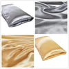 A collection of silky satin pillowcases in silver and gold colors shown folded and draped.