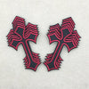 Two black and pink embroidered cross applique patches on a light gray background