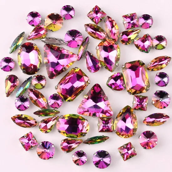 A collection of sparkling pink and green rhinestones and silver claws used for decoration.