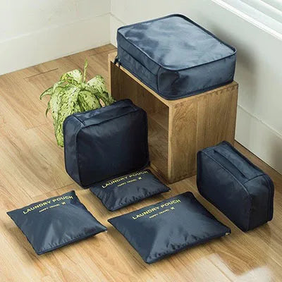 A set of six dark blue fabric laundry pouches and a wooden storage box for clothes.