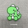 A bright green embroidered patch of a cartoon dinosaur with white accents on a gray fabric background.