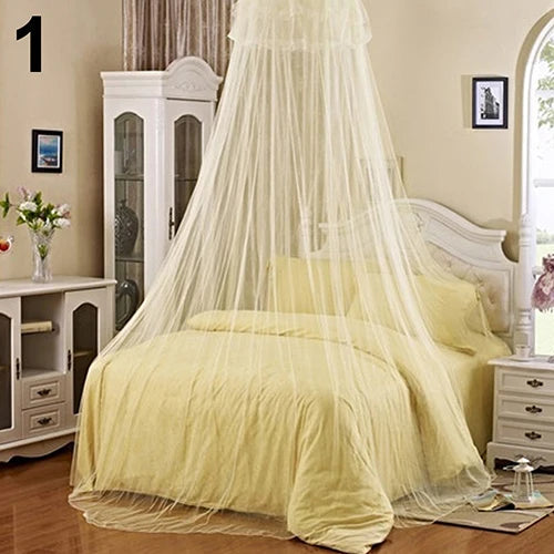 Elegant round mosquito net canopy with sheer white fabric draped over a light yellow bed.