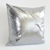 A square pillow covered in shiny silver metallic fabric.