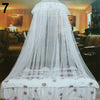 A white mosquito net canopy draped over a bed, featuring delicate lace and floral patterns.