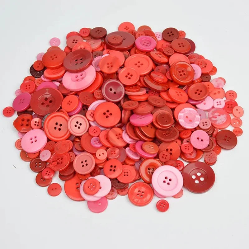A pile of mixed size wooden buttons in shades of pink and red.