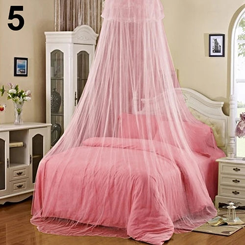 A pink mosquito net canopy draped over a bed in a bedroom setting.