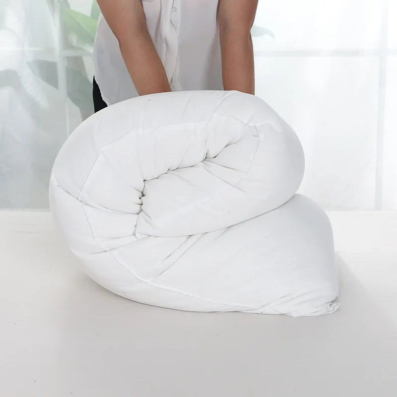 A white extra-long body pillow rolled up, demonstrating full-body support.