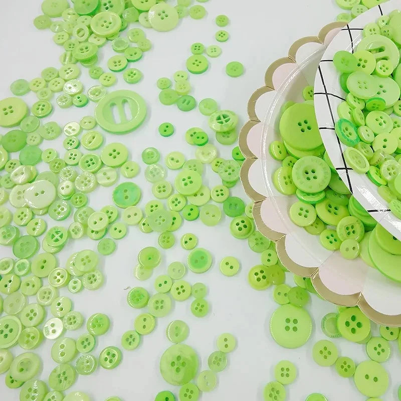 A close-up of many small, light green wooden buttons scattered across a white surface.