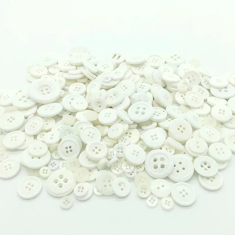 A pile of small, round, white wooden buttons for scrapbooking.