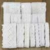 Roll of white cotton embroidered lace trim in various patterns and widths