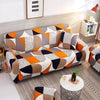 A modern sofa covered in a geometric pattern featuring orange, gray, black, and white designs.