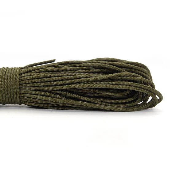 A bundle of dark olive green paracord rope coiled and laid out on a white background.
