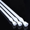 Three white adjustable metal curtain rods lying diagonally on a reflective black surface.