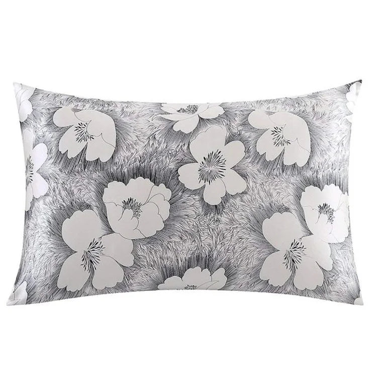 A square pillowcase with a gray and white floral print on a textured background.