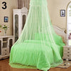 A bright lime green mosquito net canopy draped over a white bed frame in a bedroom setting.