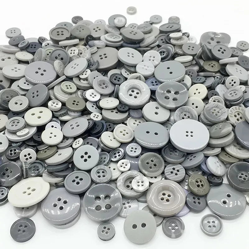 A pile of various sized wooden buttons in shades of gray and black for scrapbooking