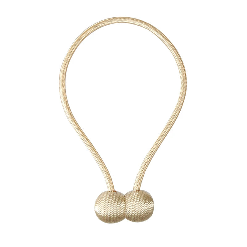 A beige magnetic pearl ball curtain tieback made of thin cord.