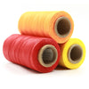 Three spools of waxed thread in orange, red, and yellow colors.