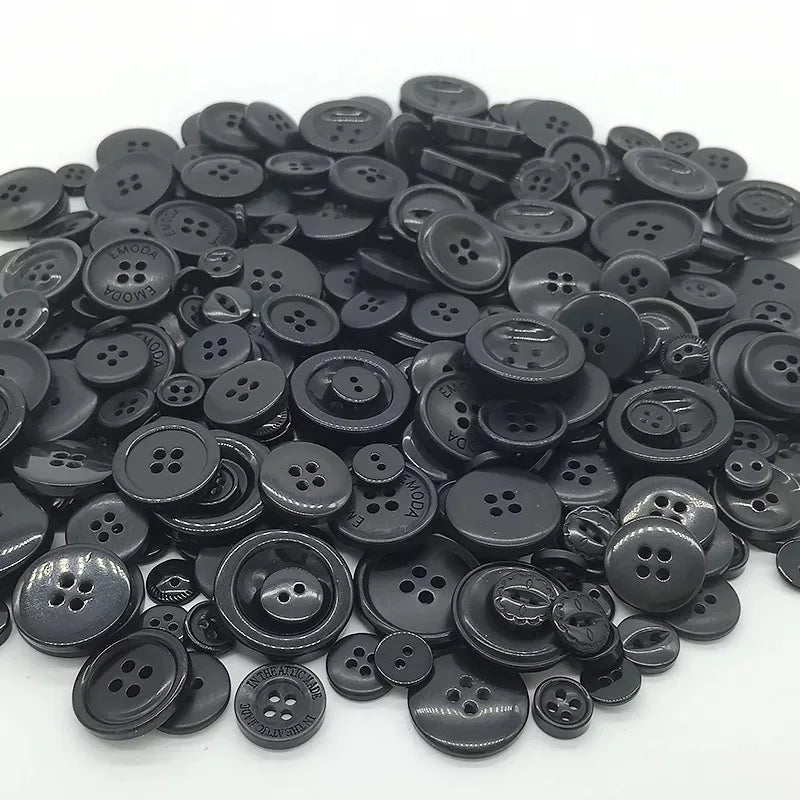 A pile of small, round, black wooden buttons for scrapbooking.