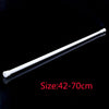 A white adjustable metal curtain rod shown diagonally against a black background.