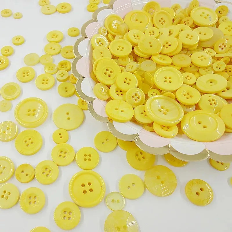 A pile of small, round, yellow wooden buttons for scrapbooking.
