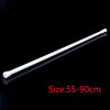 A white adjustable metal curtain rod shown diagonally against a black background.